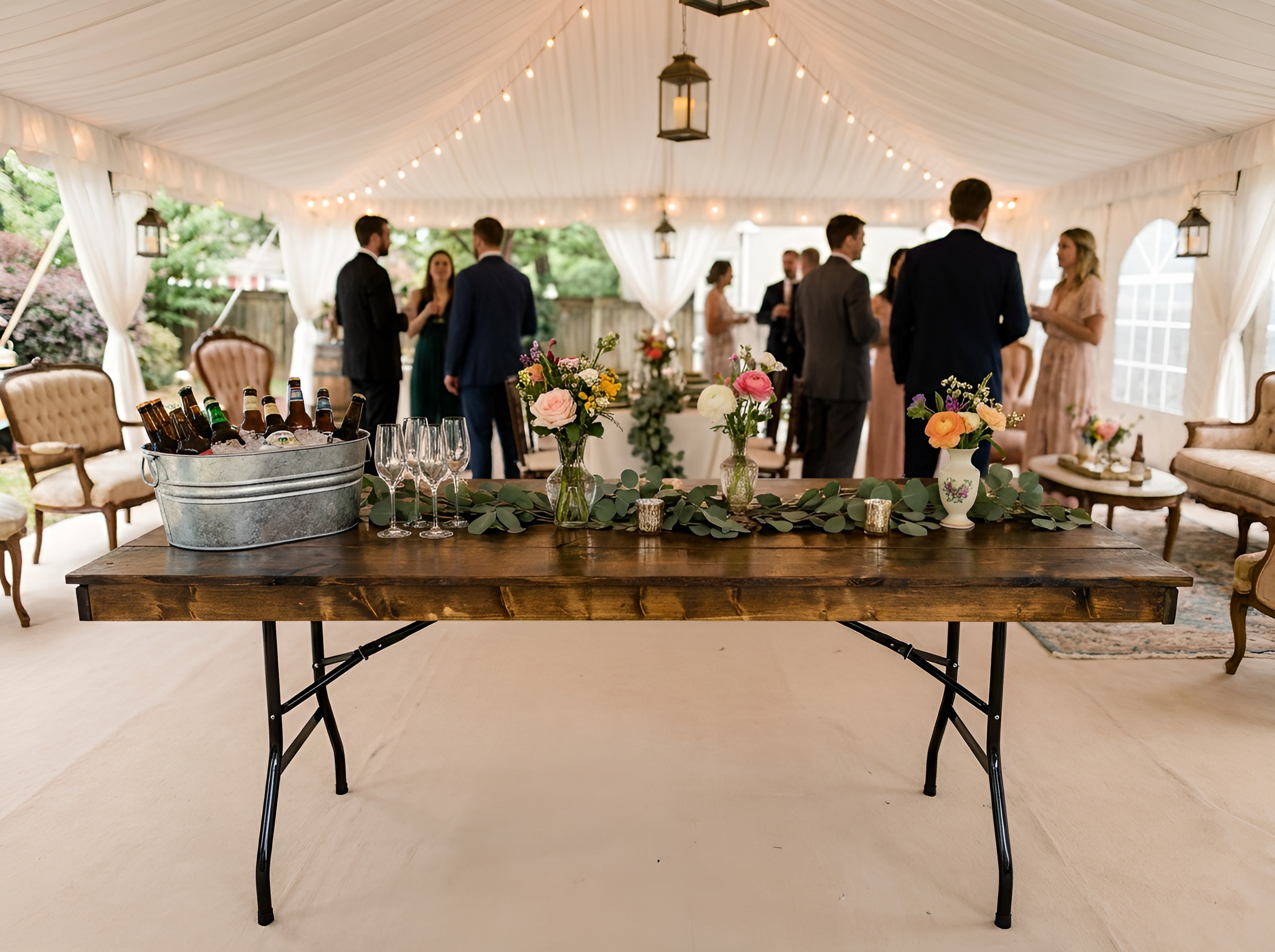 A wedding party in a tent, using a wooden table.